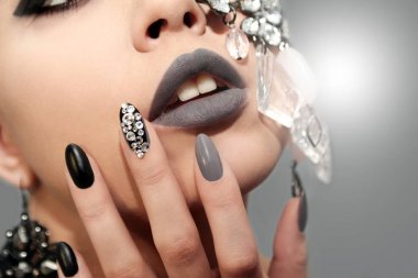 Mat siyah gri glam makyaj ve manikür rhinestones ve kızın yüzü closeup dekorasyon ile.