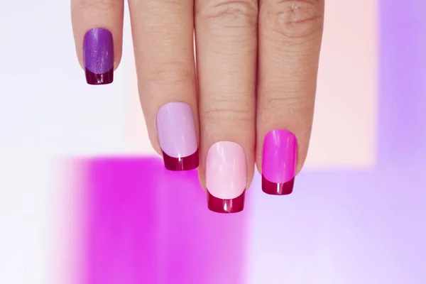 stock image Pink lilac colored French manicure on female hand close up.