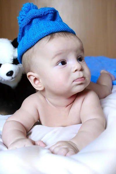 小宝宝躺在熊猫玩具旁边的床上 还挺孩子 — 图库照片