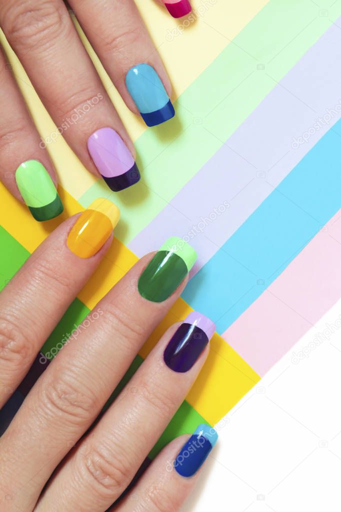 Multi-colored pastel manicure combined tone on tone with a striped background.Nail art.