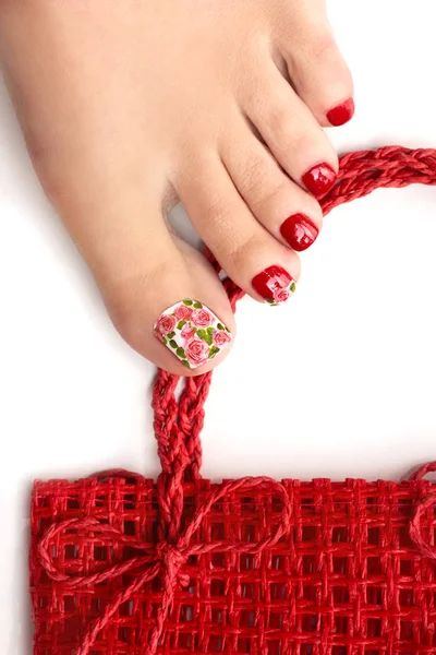 トレンディな赤い夏春のペディキュア白地に女性の脚のクローズ アップ バラのネイル デザイン — ストック写真