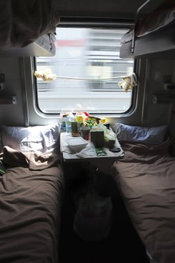 Trenle seyahat. Masada yemek ve pencereden farklı bir manzara olan farklı bir yere giderken bir vagon kompartımanı..