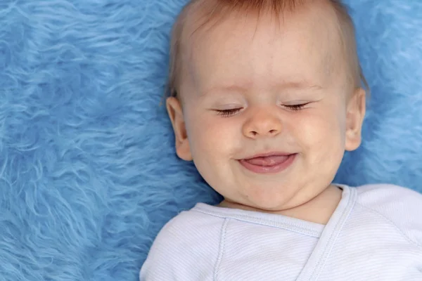一个蓝色背景的男婴的近照 儿童情绪的表达 — 图库照片