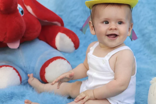 一个穿着节日服装的小孩在玩玩具 在蓝色背景下表现出积极的快乐情绪 — 图库照片