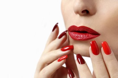 Fashionable makeup and manicure in dark red and light shades of nail Polish.Creative nail art on a young girl on a white background. clipart