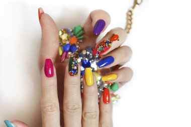 Yaratıcı, parlak manikürlü, yapay elmaslı uzun tırnaklar. Kadınların elinde manikür, kostüm takılı beyaz arka planda..