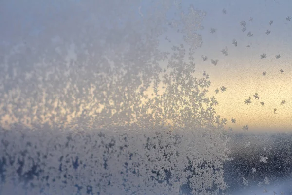 Flocons de neige sur une fenêtre en verre au lever du soleil . — Photo