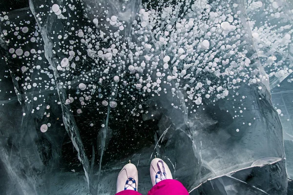 Skater in the pink pants on beautiful fairytale ice of the lake Baikal and bubbles in ice. — Stock Photo, Image