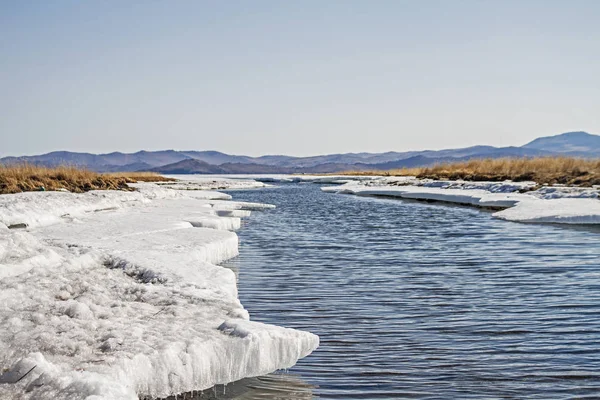 Rzeka góry zimą wśród suchej trawy na Bajkał, śnieg i sople. — Zdjęcie stockowe