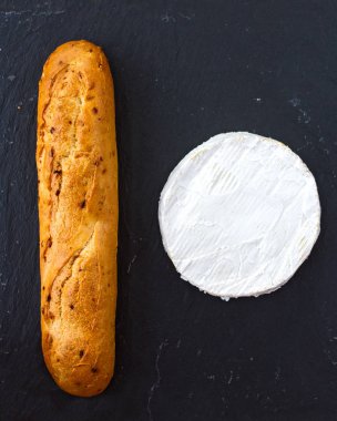 Dokulu arka plan altın taze gevrek baget ve İsviçre Camembert peyniri siyah bir sayısı on şeklinde.