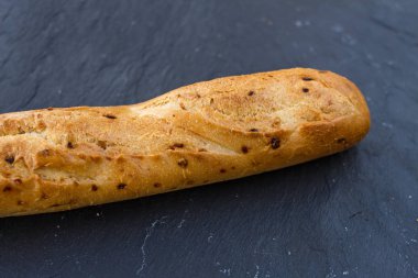 Fransız iştah açıcı taze çıtır çıtır kızarmış altın baget siyah grafit arka plan üzerinde soğanlı.