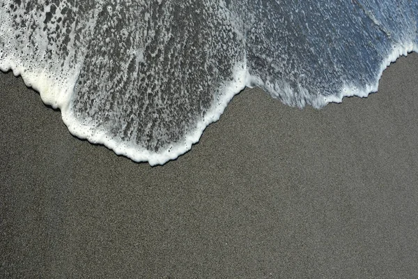 Zand en golven als achtergrond — Stockfoto