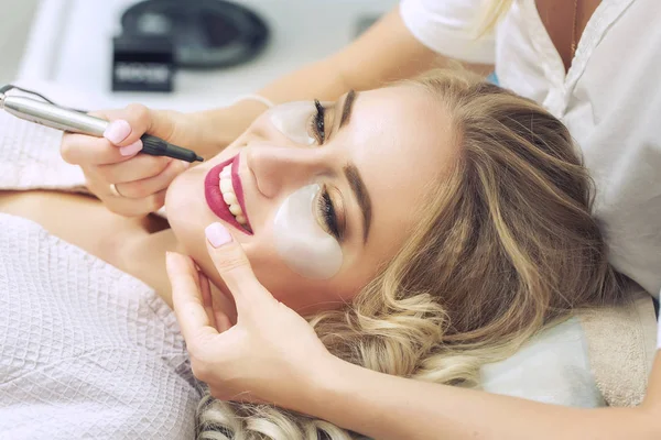 Косметолог наносит постоянный макияж на губы — стоковое фото