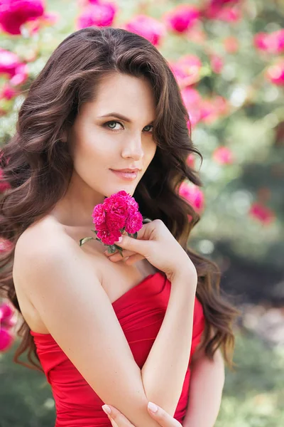 Νεαρή γυναίκα με ένα ροζ λουλούδι. Υπαίθριο θερινό πυροβόλησε — Φωτογραφία Αρχείου
