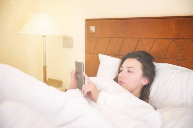 telefon ile yatakta kadın