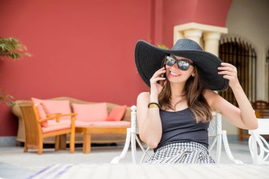 konuşan büyük siyah şapkalı kadın