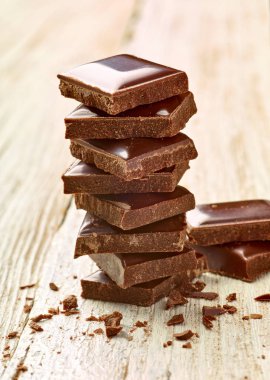 Tahta arka planda çikolata parçalarını kapat