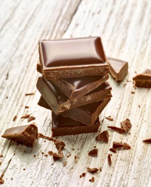 Tahta arka planda çikolata parçalarını kapat