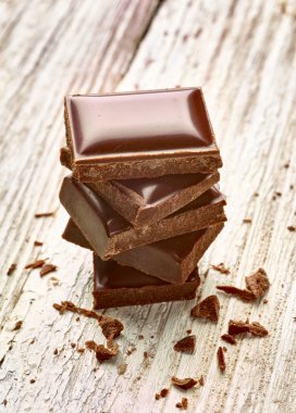 Tahta arka planda çikolata parçalarını kapat