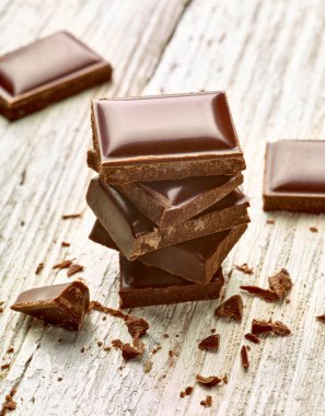 Tahta arka planda çikolata parçalarını kapat