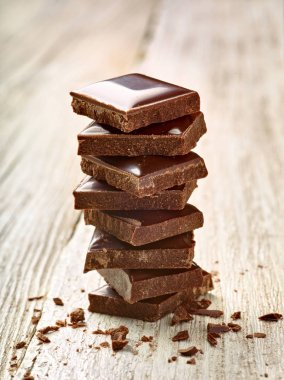 Tahta arka planda çikolata parçalarını kapat