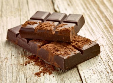 Tahta arka planda çikolata parçalarını kapat