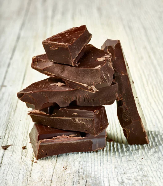 Tahta arka planda çikolata parçalarını kapat