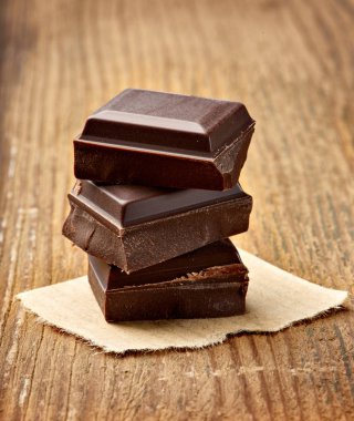 Tahta arka planda çikolata parçalarını kapat