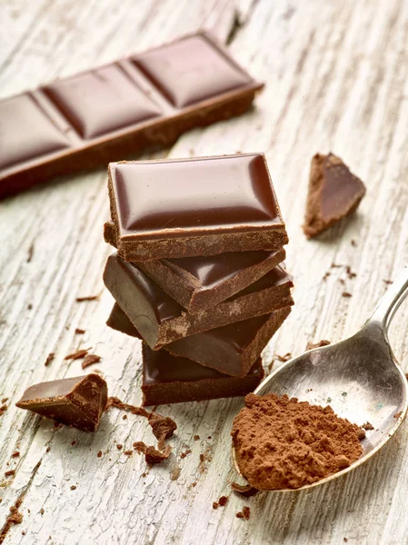 Tahta arka planda çikolata parçalarını kapat