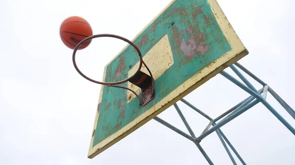 old basketball hoop bottom view outdoors sport rusty iron ball enters the basket