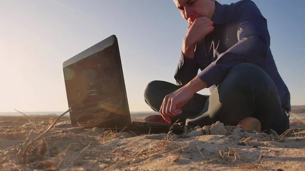 Freelancing. Man working on laptop in nature, businessman freelancer Freelancing, work on the Internet silhouette