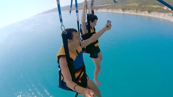 Parapente y parasailing estilo de vida. El hombre y el niño están volando en un paracaídas sobre el mar. Deporte extremo vista en primera persona — Vídeos de Stock