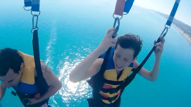 Man en jongen paragliden en parasailen. vliegen op een parachute boven de zee. Extreme sport eerste persoonsmening levensstijl — Stockvideo