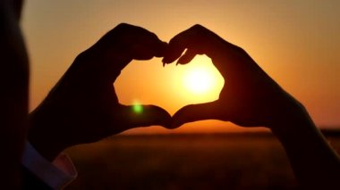 gün batımı siluet ile kalp şekli oluşturan eller. el-şekil günbatımı siluet ile kalp şekli oluşturan güneş eller için