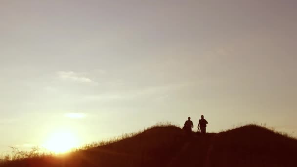 Menschen Gruppe von Touristen zu Fuß auf einem Reise Sonnenuntergang Silhouette Berg. Langsam Video Touristen Menschen Gruppe gehen in die Natur — Stockvideo