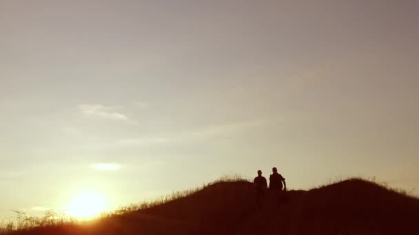 Grupo de pessoas de turistas andando no topo de uma montanha silhueta viagem por sol. lento vídeo turistas pessoas grupo ir natureza — Vídeo de Stock