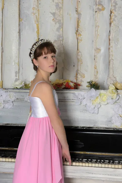 ピアノの横にあるお祭りスマート ピンクのドレスの女の子 — ストック写真