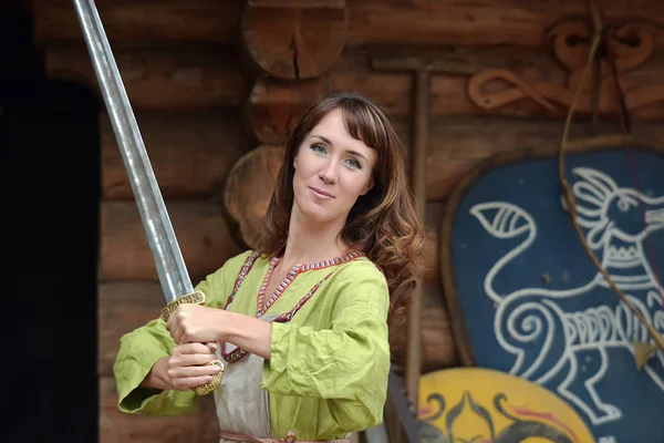 Woman in a green dress with a sword in hand. — Stock Photo, Image