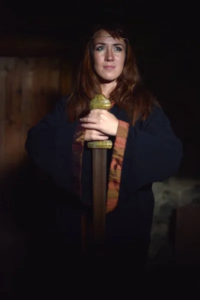 Femme dans une robe sombre avec épée — Photo