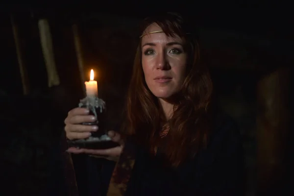 一个女人在黑暗中手里拿着蜡烛的肖像 — 图库照片