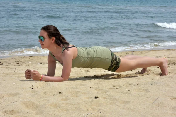En tjej som gör sport på stranden — Stockfoto
