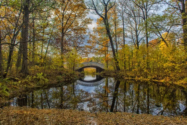Мост через канал в осеннем парке — стоковое фото
