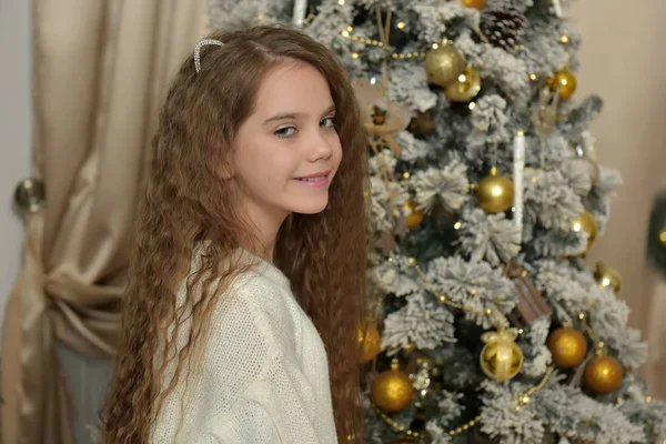 Chica en un suéter blanco cerca del árbol de Navidad — Foto de Stock
