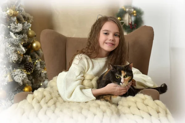 クリスマスに猫と肘掛け椅子の少女 — ストック写真