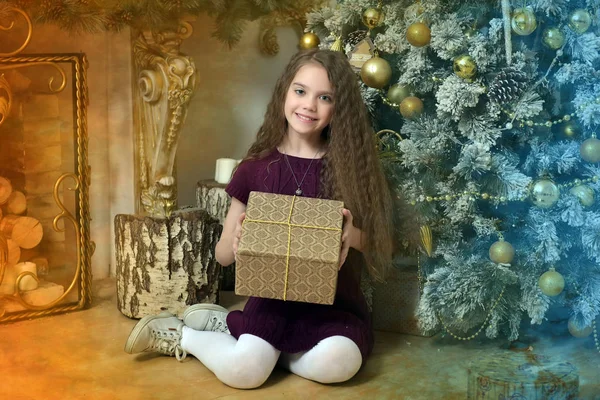 Girl with long hair in a dress with a gift in the hands — Stock Photo, Image