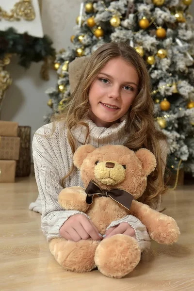 Girl teenager in a knitted sweater with a teddy bear at the Chri — Stock Photo, Image