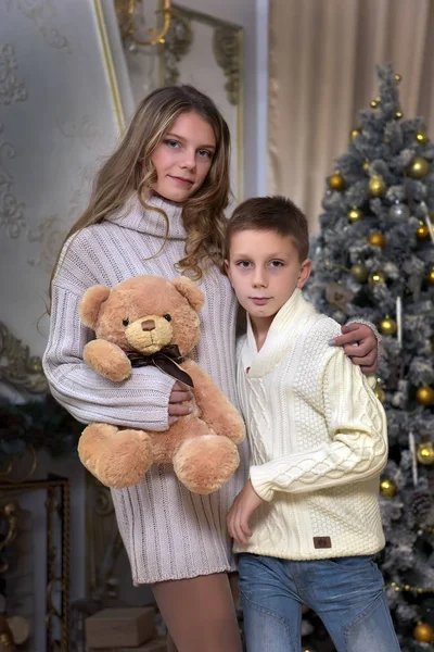 妹のティーンエイ ジャーとクリスマスのクリスマス ツリーでテディベアを持つ少年 — ストック写真