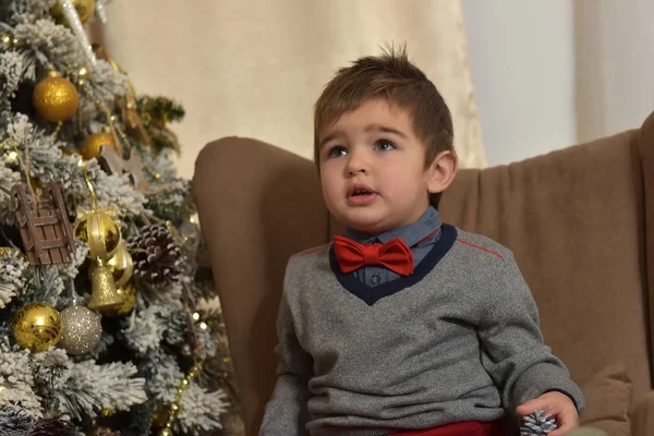 Een Jongen Rode Broek Een Vlinderdas Zit — Stockfoto