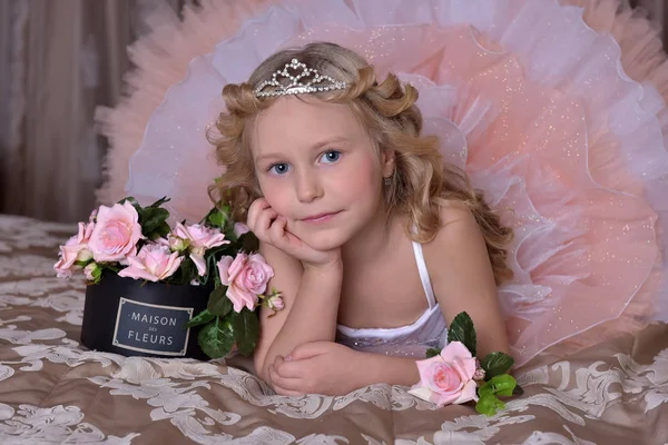 穿白色衣服的女孩穿着粉红色的连衣裙 在沙发上放着花的王冠 — 图库照片