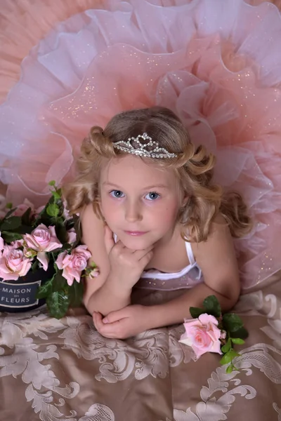 ピンクのドレスと白の花が付いているソファーに Diadem で女の子 — ストック写真